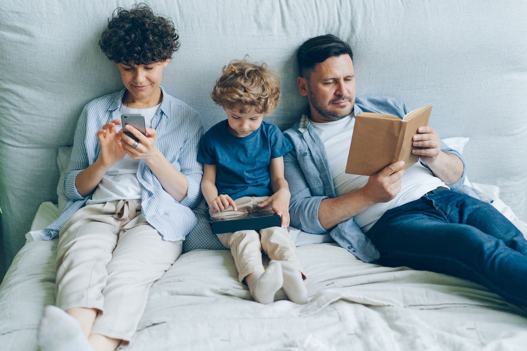 Parents and two children relaxing together in a comfortable bedroom