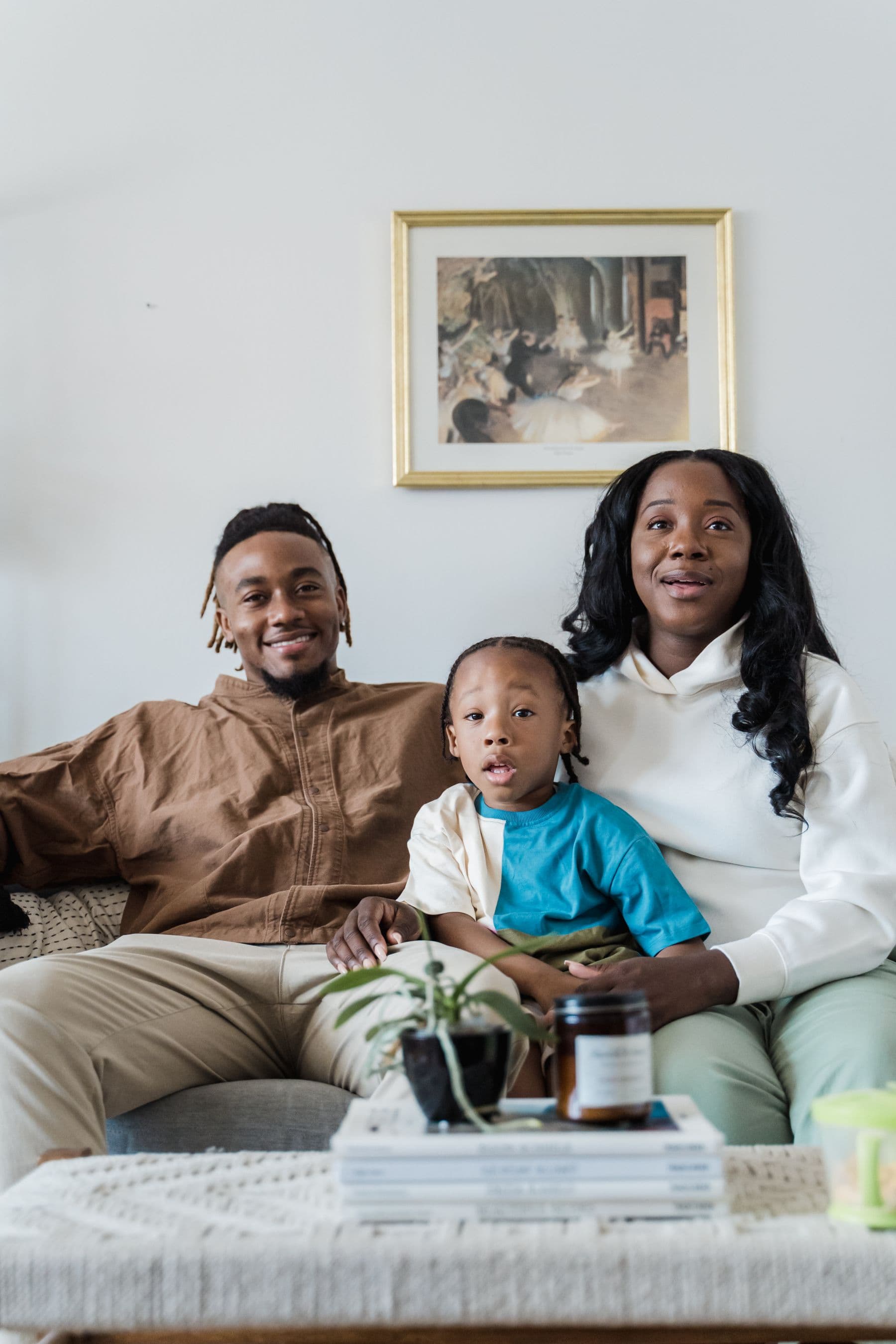 Family of three relaxing together on a couch at home