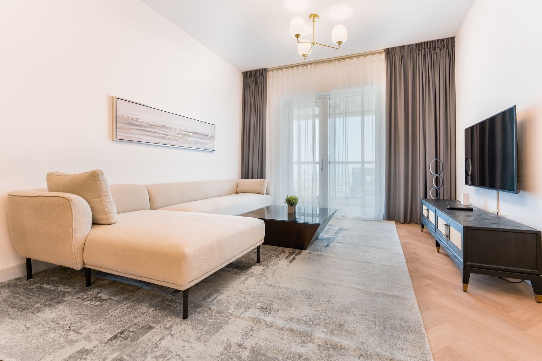 Bright, comfortable living room with a cream sectional sofa and large windows